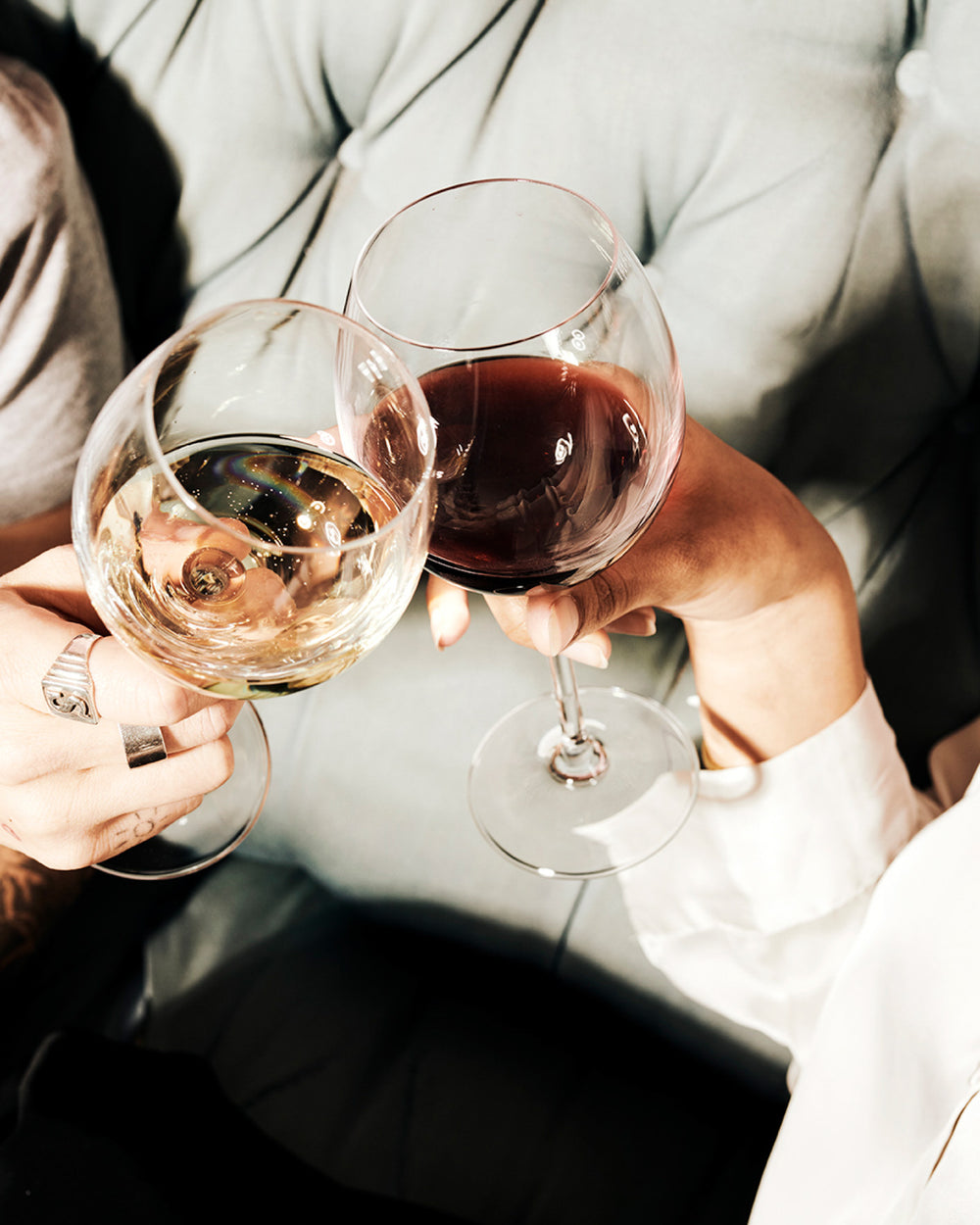 two people holding wine glasses together